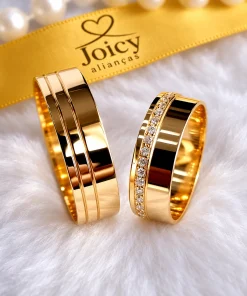 Par de alianças Elegance Duo em ouro 18K, masculina com dois frisos e feminina com zircônias, sobre superfície branca