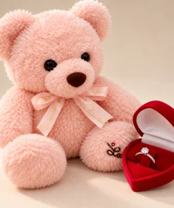 Urso de pelúcia rosa com laço dourado e caixinha de veludo vermelha em formato de coração com anel solitário de pedra brilhante